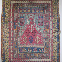 Central Anatolian Village Rug  - Probably woven in Kirshehir or environs in the second half of the 19th century, this is a superb example of Central Anatolian village weaving. It has everything - soft plush wool, wonderful natural dyes and a design replete with the complexity of ancient Anatolian imagery. The raspberry filed within the prayer niche is filled with anchor style ornaments. Note too, the intriguing panel at the tip of the prayer niche and the taupe inner border with rows of 'L' shaped figures The colour combination is daring yet subtle, and the entire composition has great balance. This is a truly great Anatolian village rug, both highly collectible and decorative. Image of Central Anatolian Village Rug